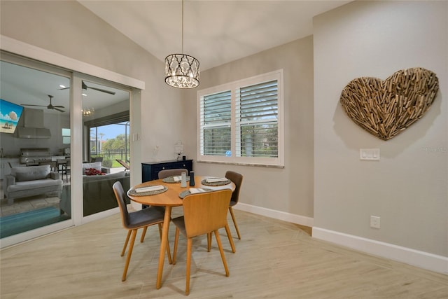 dining room featuring ceiling fan with notable chandelier and light hardwood / wood-style flooring