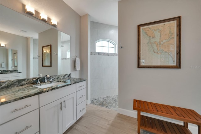 bathroom with vanity and a tile shower