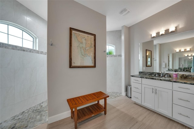 bathroom with vanity and a tile shower