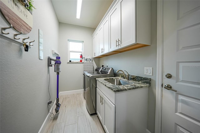 laundry room with cabinets, separate washer and dryer, and sink