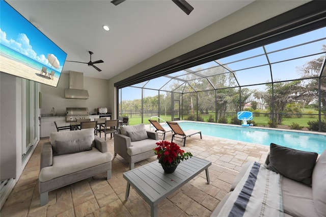 view of swimming pool with area for grilling, sink, and ceiling fan