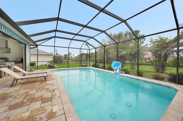 view of pool featuring a yard, a lanai, exterior kitchen, and a patio