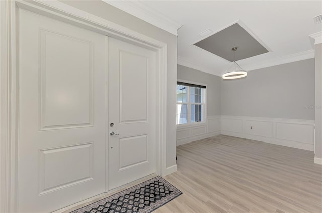 foyer featuring ornamental molding and light hardwood / wood-style floors