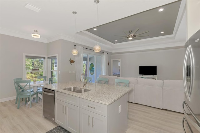 kitchen featuring sink, hanging light fixtures, a raised ceiling, stainless steel appliances, and white cabinets