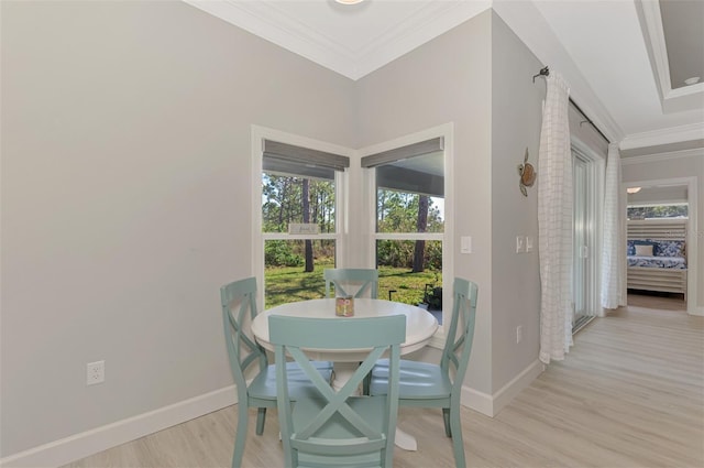 dining area featuring crown molding and light hardwood / wood-style flooring