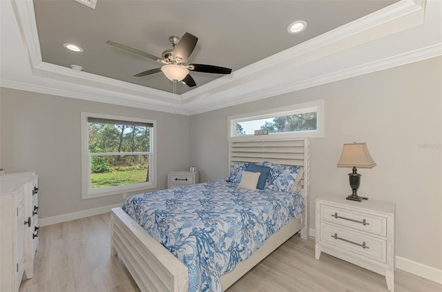 bedroom featuring a raised ceiling, crown molding, ceiling fan, and light hardwood / wood-style floors