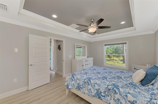 bedroom with light hardwood / wood-style floors, ornamental molding, a raised ceiling, and ceiling fan