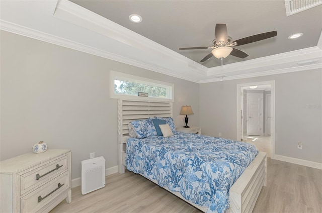 bedroom featuring crown molding, ceiling fan, light wood-type flooring, and a tray ceiling