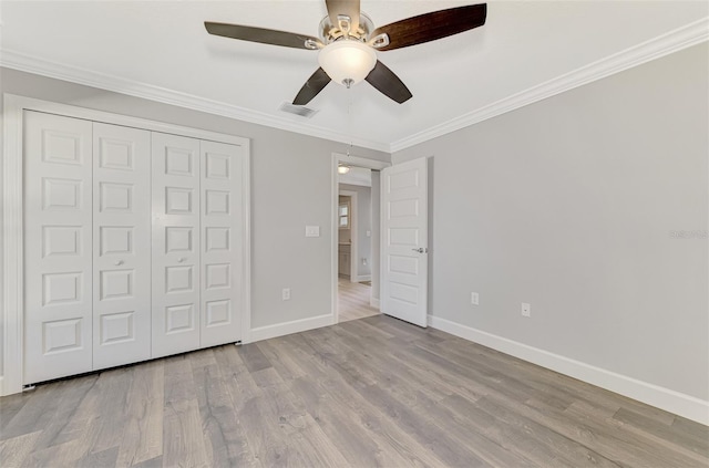 unfurnished bedroom with crown molding, ceiling fan, light hardwood / wood-style floors, and a closet