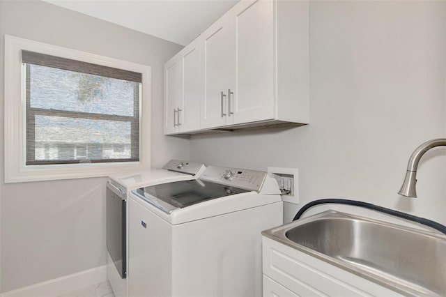 clothes washing area featuring independent washer and dryer, cabinets, and sink