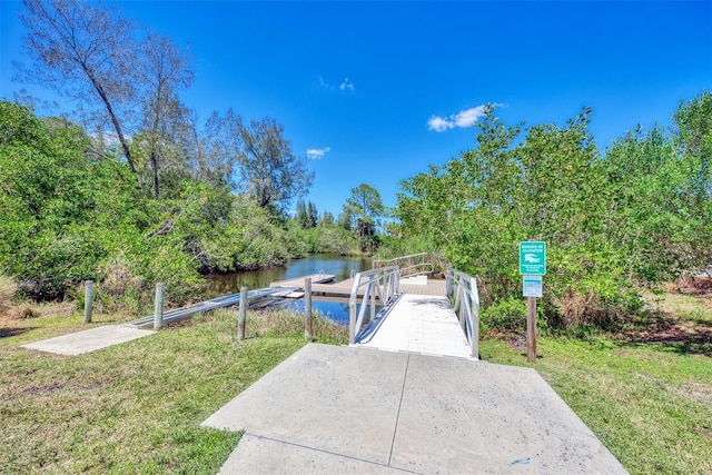 view of home's community featuring a yard, a dock, and a water view