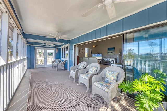 sunroom featuring a ceiling fan and french doors