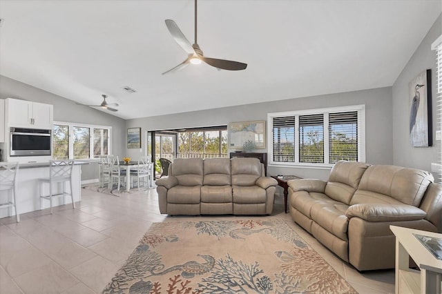 living area with lofted ceiling, light tile patterned floors, visible vents, and a ceiling fan