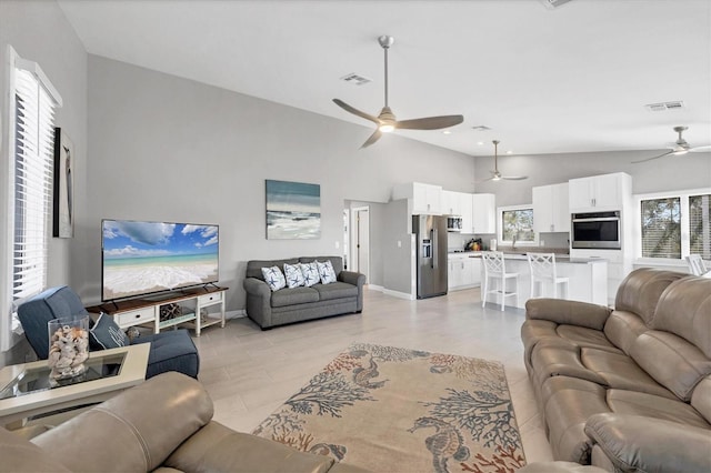 living area with baseboards, high vaulted ceiling, visible vents, and a ceiling fan