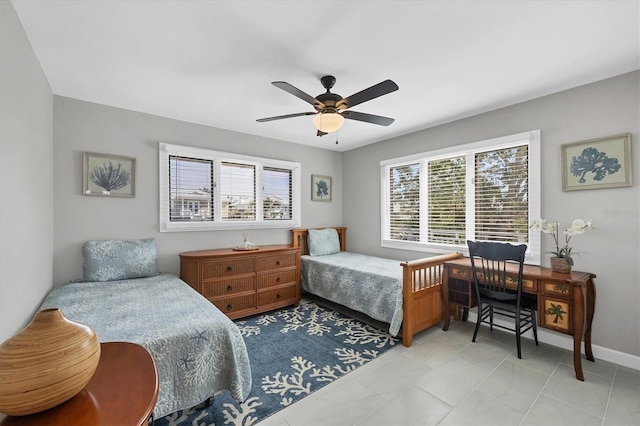 bedroom with a ceiling fan, multiple windows, and baseboards