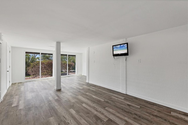 unfurnished living room featuring baseboards and wood finished floors