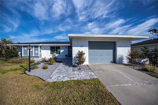 single story home with a garage and a front lawn