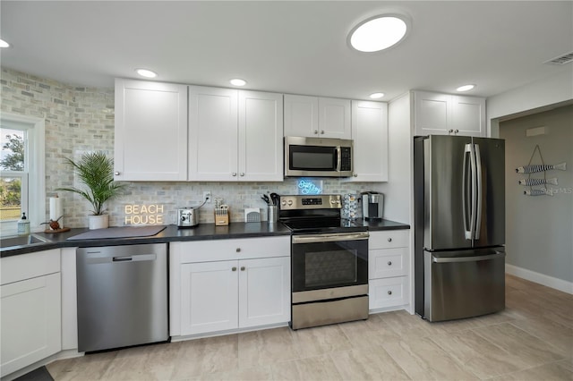 kitchen with white cabinetry, appliances with stainless steel finishes, sink, and decorative backsplash