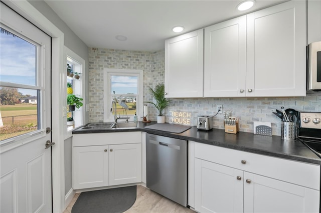 kitchen featuring white cabinetry, appliances with stainless steel finishes, sink, and tasteful backsplash