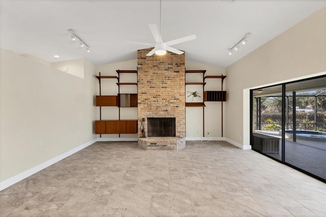 unfurnished living room with a fireplace, track lighting, ceiling fan, and vaulted ceiling