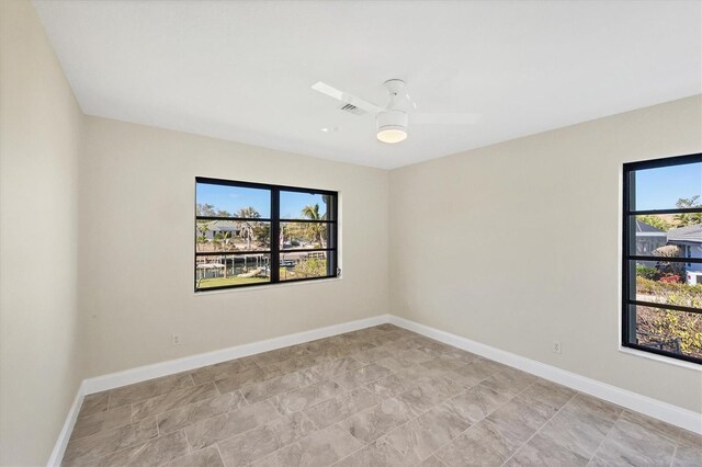 unfurnished room featuring plenty of natural light and ceiling fan