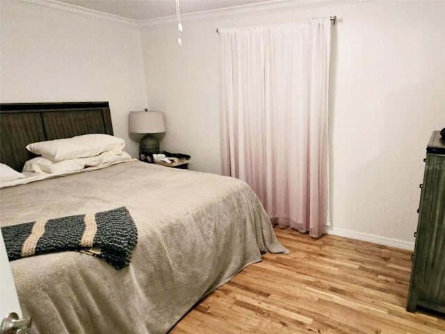 bedroom featuring crown molding and wood-type flooring