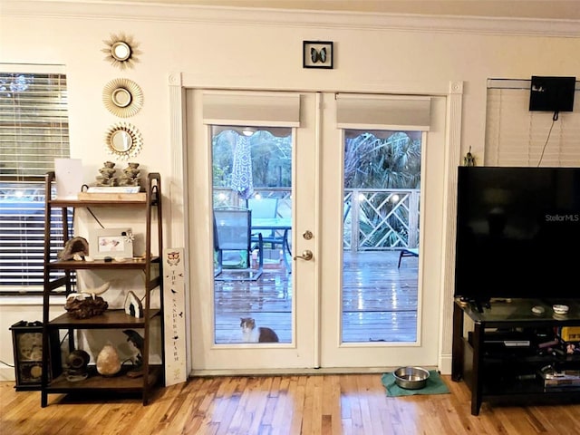 doorway to outside featuring crown molding, wood-type flooring, and french doors