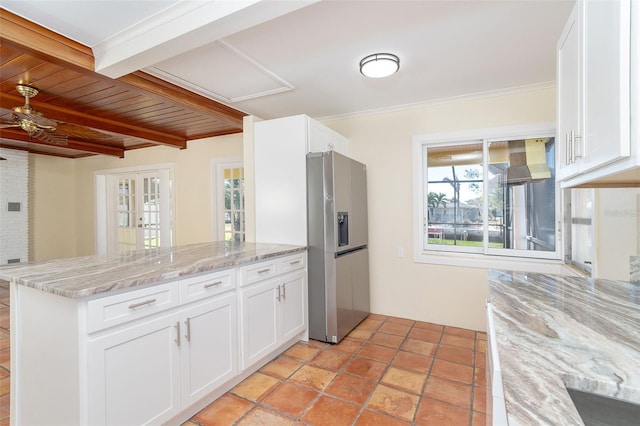 kitchen with white cabinets, stainless steel fridge, light stone counters, and kitchen peninsula