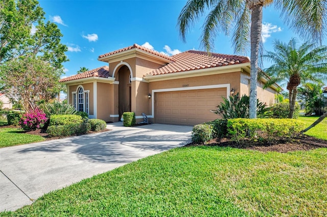 mediterranean / spanish-style home featuring a garage and a front lawn