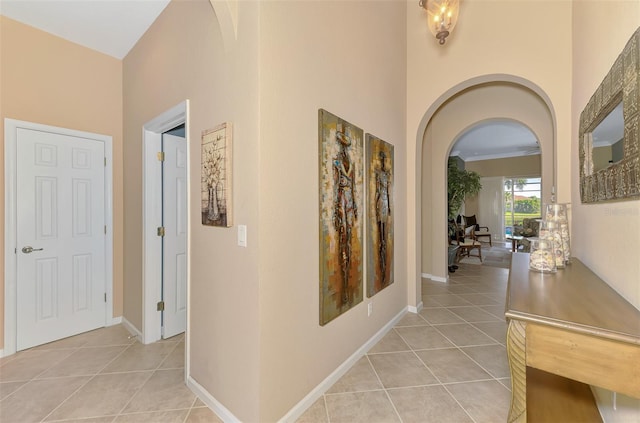 corridor featuring a high ceiling and light tile patterned floors