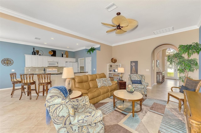 tiled living room featuring sink, ornamental molding, and ceiling fan