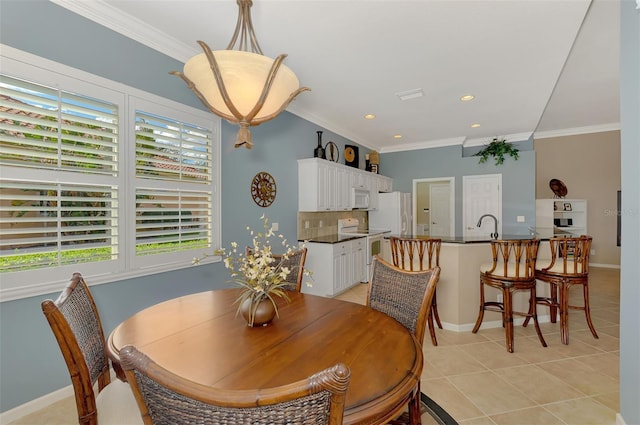 dining space featuring ornamental molding and light tile patterned flooring