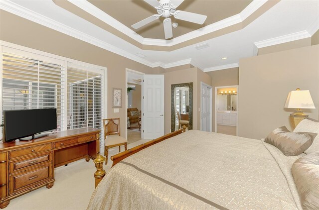 bedroom featuring ceiling fan, carpet flooring, ensuite bathroom, ornamental molding, and a raised ceiling