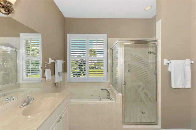 bathroom featuring a healthy amount of sunlight, separate shower and tub, and vanity