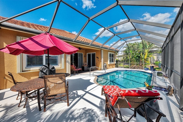 view of pool featuring ceiling fan, glass enclosure, and a patio area