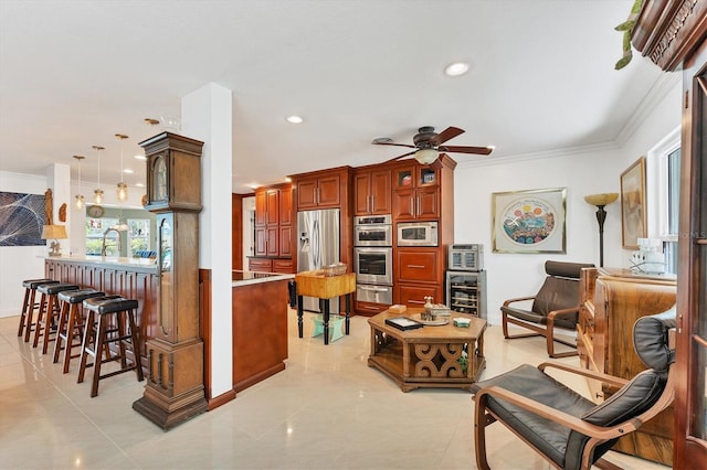 kitchen featuring decorative light fixtures, ornamental molding, stainless steel appliances, and kitchen peninsula