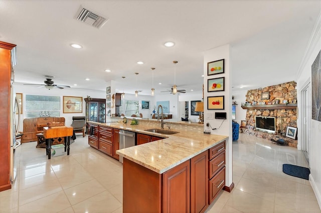 kitchen with sink, light tile patterned floors, light stone counters, decorative light fixtures, and kitchen peninsula