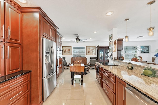 kitchen featuring light stone counters, light tile patterned floors, pendant lighting, ceiling fan, and stainless steel appliances