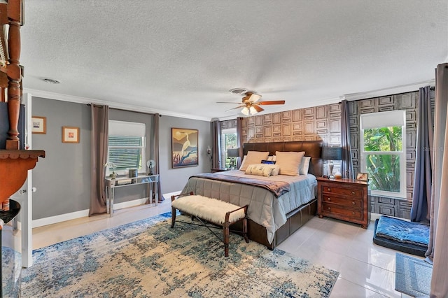 bedroom with ornamental molding, light tile patterned flooring, ceiling fan, and a textured ceiling