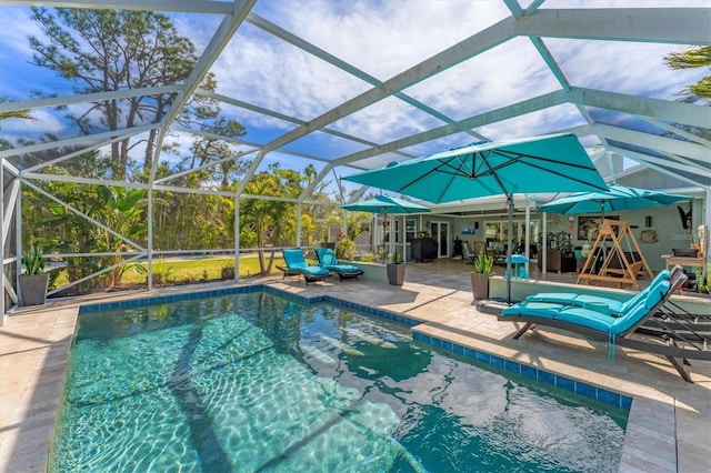 view of pool with a patio and glass enclosure