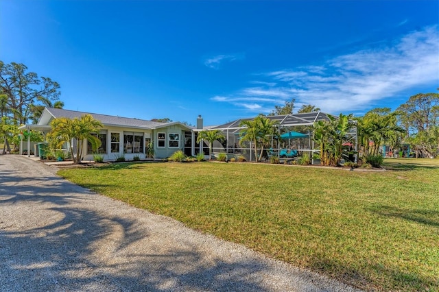 view of front facade with a front yard and glass enclosure