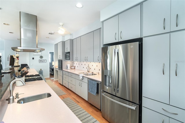 kitchen with sink, light hardwood / wood-style flooring, backsplash, stainless steel appliances, and island range hood