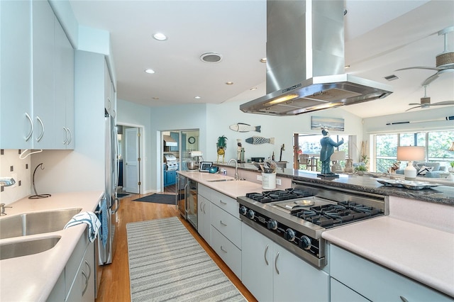 kitchen with sink, island range hood, stainless steel gas stovetop, and ceiling fan