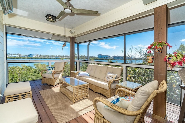 sunroom / solarium with a water view and ceiling fan