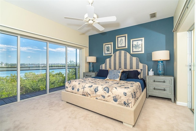 carpeted bedroom with a water view, ceiling fan, and access to outside