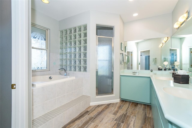 bathroom featuring shower with separate bathtub and vanity