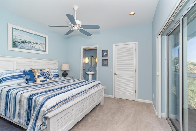 bedroom featuring ensuite bathroom, light colored carpet, access to exterior, and ceiling fan