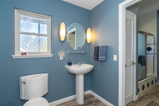 full bathroom with wood-type flooring, sink, shower / bath combination with glass door, and toilet