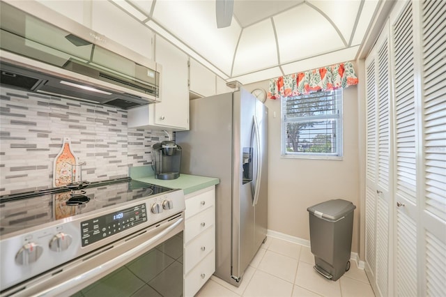 kitchen featuring tasteful backsplash, ventilation hood, light tile patterned floors, appliances with stainless steel finishes, and white cabinets