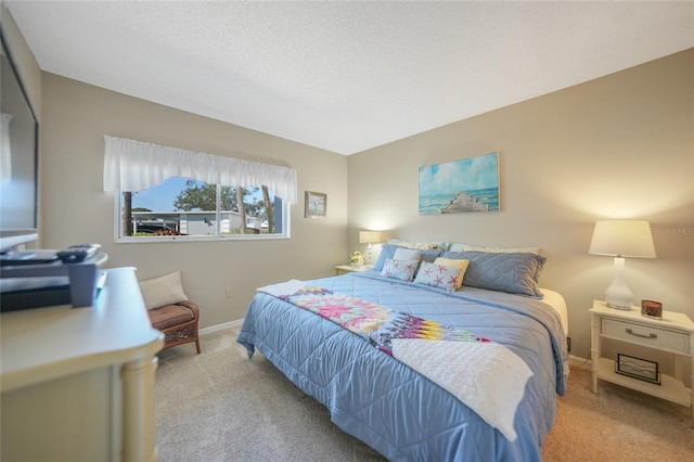 bedroom featuring light carpet and a textured ceiling